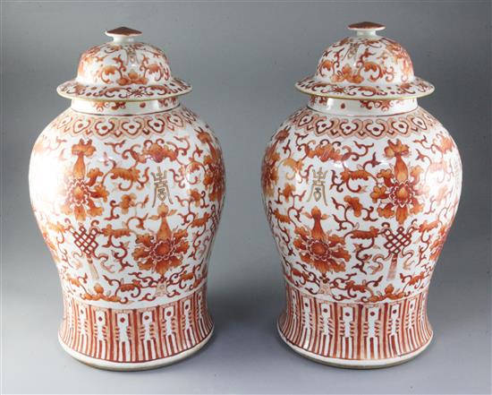 A pair of large Chinese iron red and gilt decorated baluster jars and cover, 19th century, height 43cm, chips to finials on covers